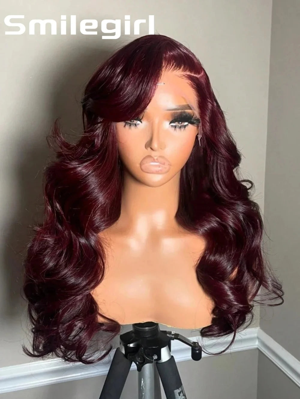 A model displays a long, wavy burgundy human hair wig on a display stand.