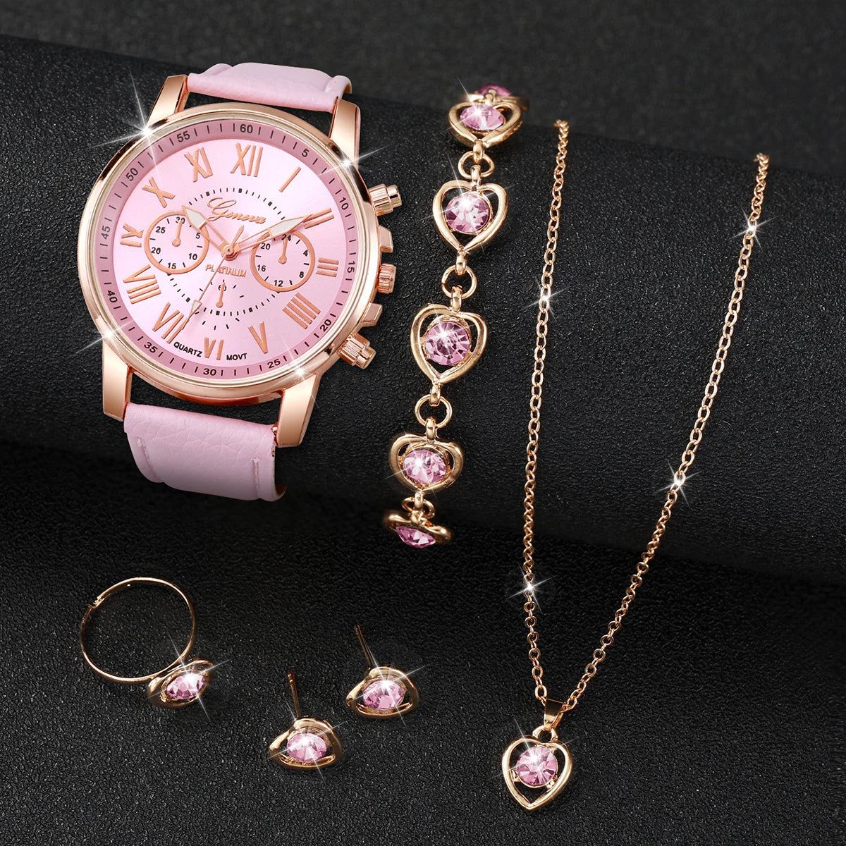 A pink quartz wristwatch with gold accents and a matching gold chain necklace are displayed on a dark surface.