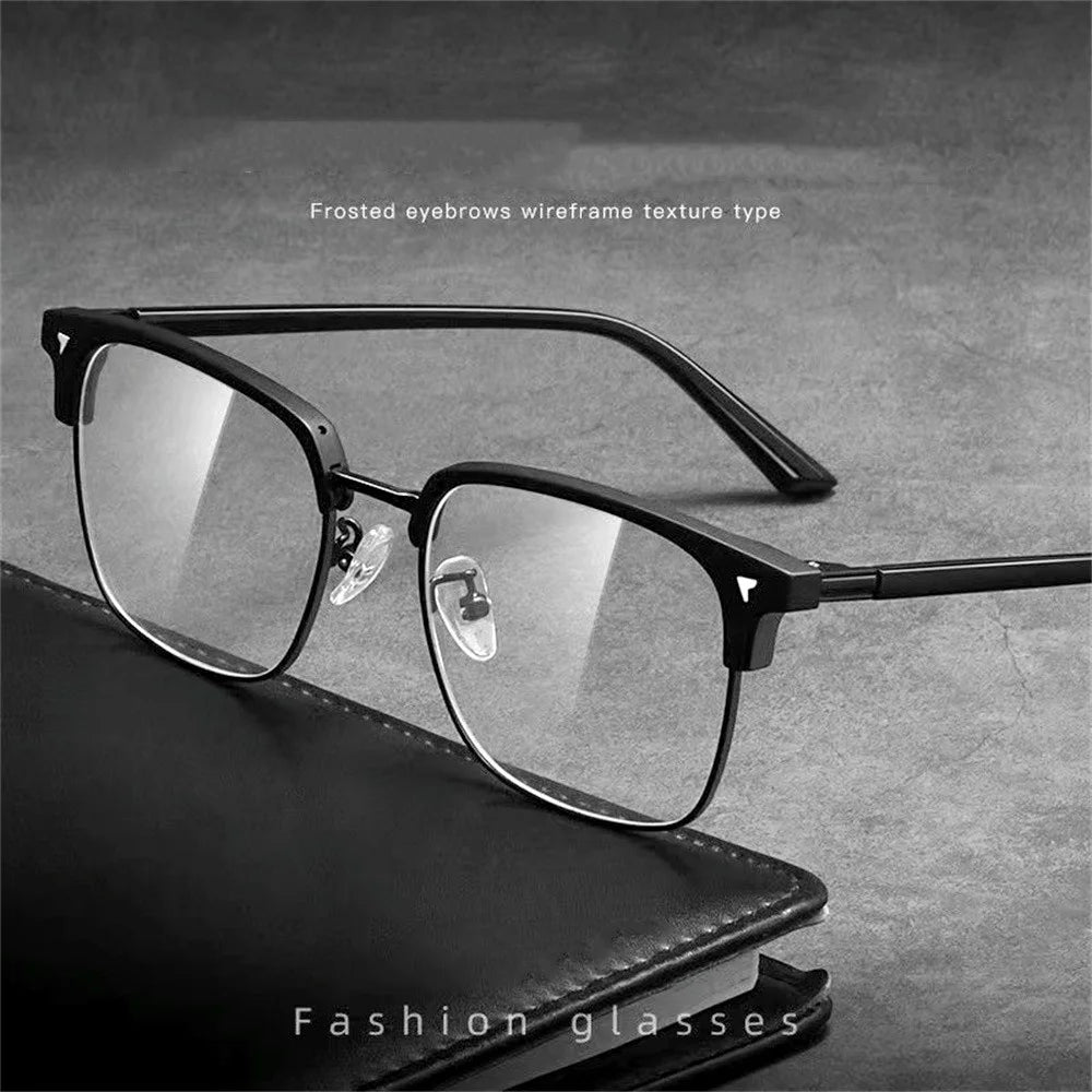 A pair of black anti-blue light clear wireframe eyeglasses resting on a dark leather case.