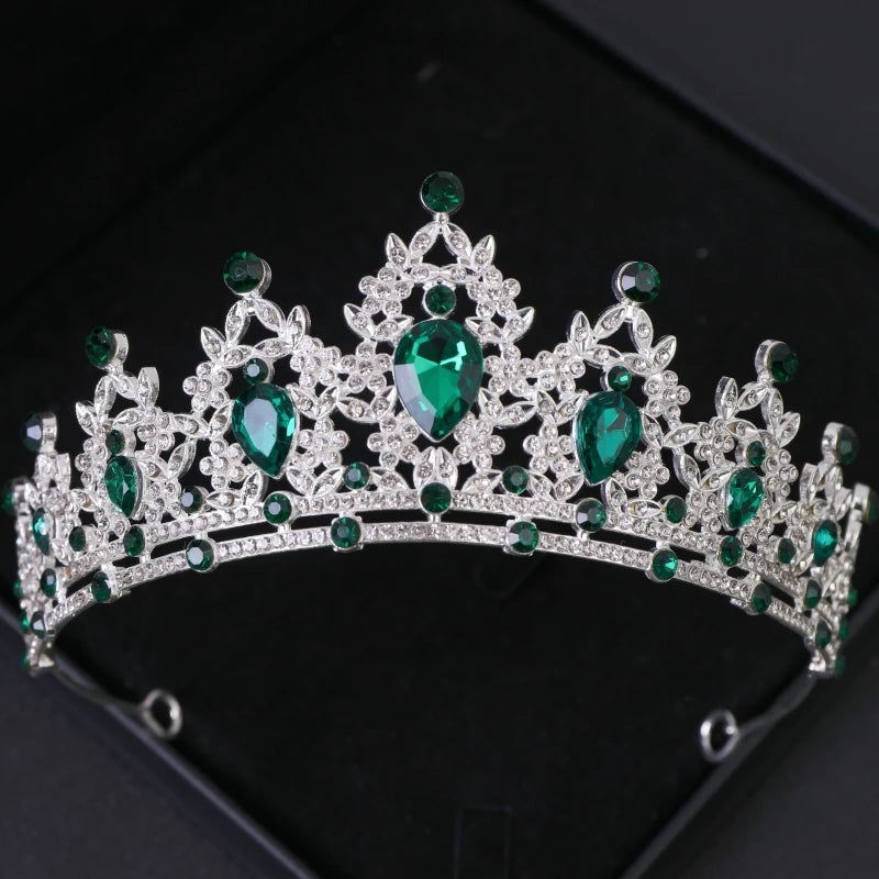 Couronne de diadème argentée avec des gemmes vertes et un travail de filigrane complexe.