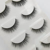 A set of handmade mink strip eyelashes displayed on a white tray.