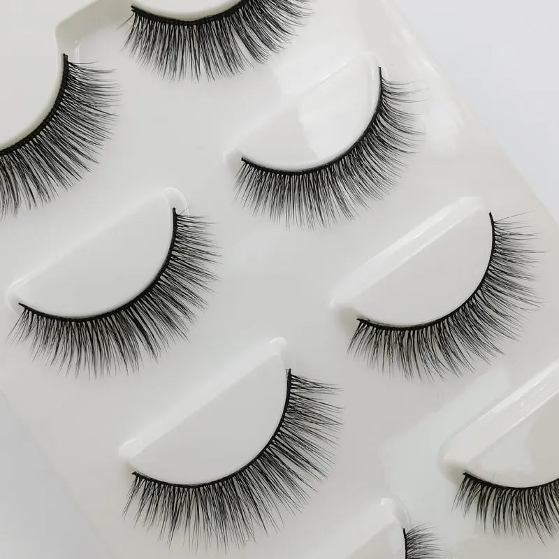 A set of handmade mink strip eyelashes displayed on a white tray.