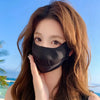 A woman wearing a black breathable ice silk UV protection face mask against a bright blue sky background.