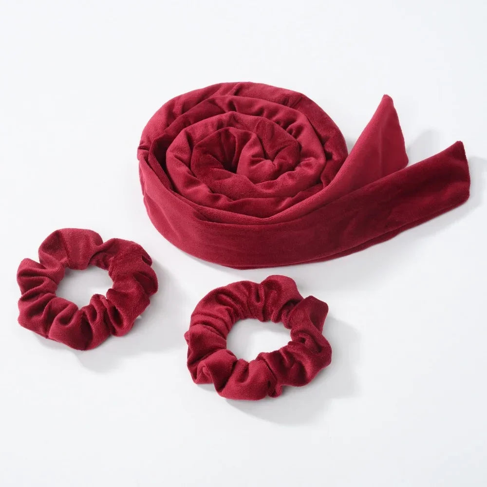 Un bandeau de fer à boucler pour cheveux en velours rouge profond, roulé en spirale.