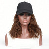 A model wearing a black adjustable short wave wig and a black cap against a white background.