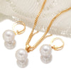 A set of dainty gold pearl jewelry featuring matching earrings and a delicate chain necklace displayed on a white lace fabric