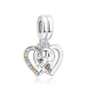 A silver family tree charm necklace featuring a heart pendant and a small charm.