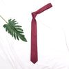 A maroon men's slim jacquard business tie draped on a white cloth.