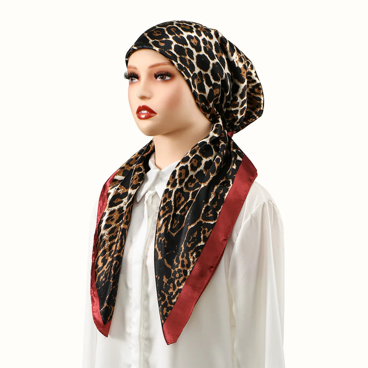 A woman models a black and brown leopard print satin silk hijab headband cap with a maroon trim.