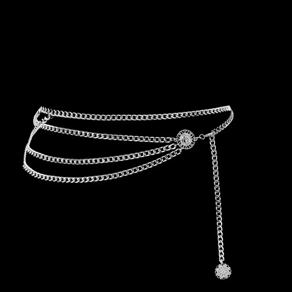 A silver chain belt featuring multiple strands and a decorative crystal embellishment.