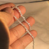 Eine Hand hält eine Sterlingsilber-Halskette für die Schlüsselbein mit 2mm funkelnden Elementen.