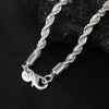 A silver twisted rope necklace and bracelet set displayed on a dark surface.
