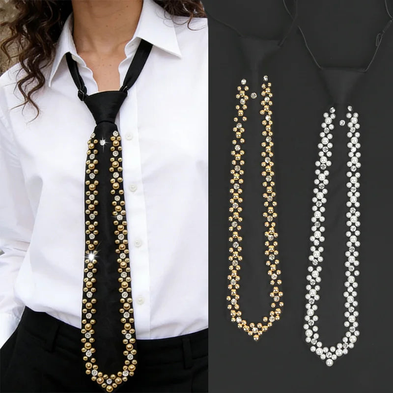 A black silk neck tie adorned with gold and clear rhinestones and pearls, displayed against a white shirt.