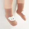 A pair of beige knitted socks featuring a white cartoon sheep design for kids