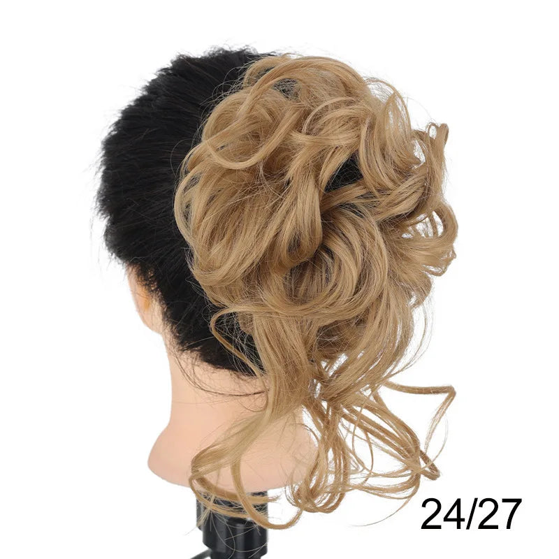 A woman's dark hair styled in a voluminous, messy blonde bun with long flowing curls.