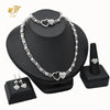 A silver heart crystal necklace and matching earrings displayed on a black stand.