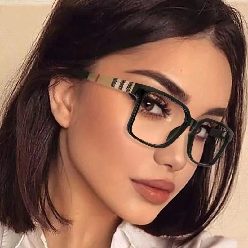 Close-up of a woman wearing black rectangular anti-blue light eyeglasses with gold accents.