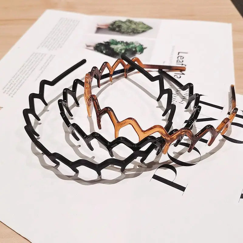 A set of black and brown anti-slip toothed hair accessories arranged on a white paper.