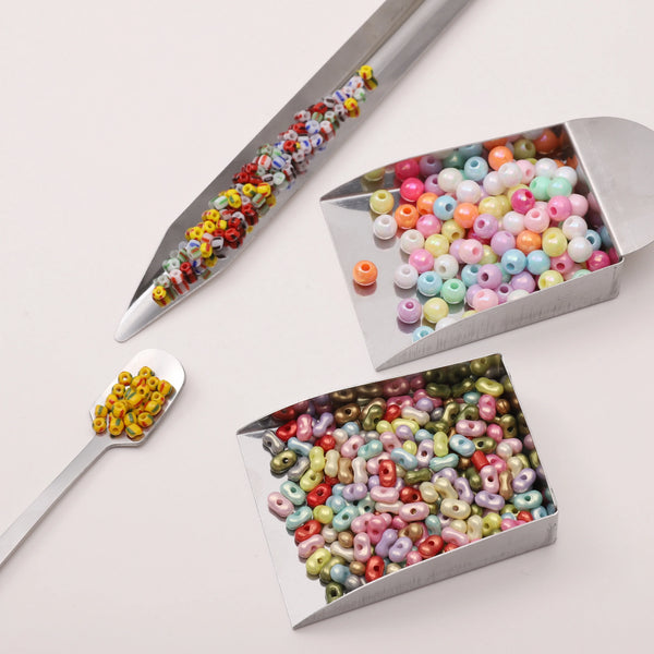 Outil en acier inoxydable avec une aiguille longue pour déplacer des perles colorées dans un plateau de fabrication de bijoux