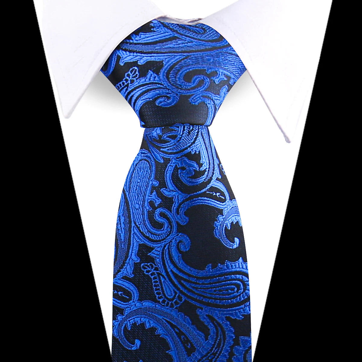 A close-up of an elegant blue and black floral paisley silk necktie worn with a white shirt.