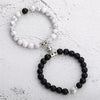 A pair of natural stone heart couple bracelets featuring white and black marbled beads.