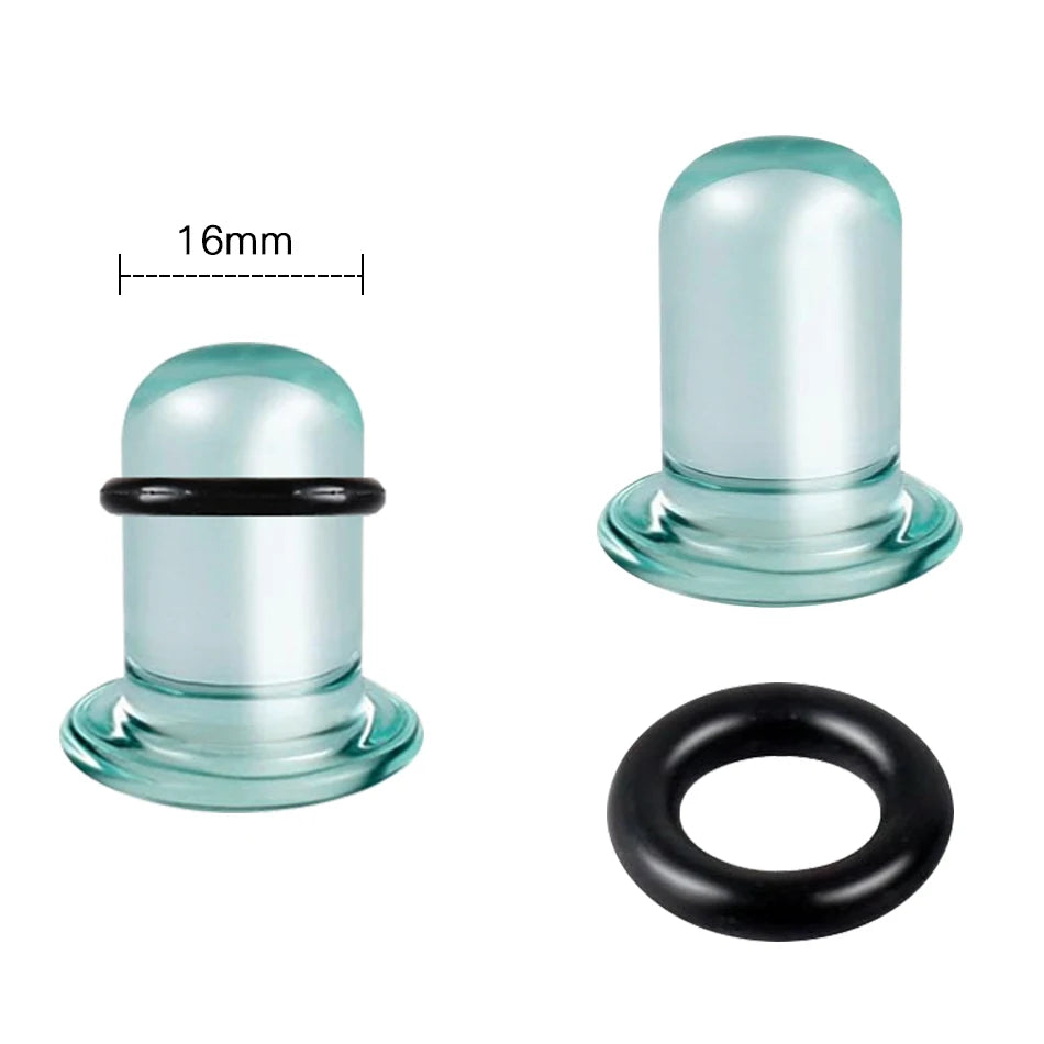 A clear glass ear stretching plug with a black ring and a separate black rubber ring.