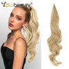 A model shows off 32-inch synthetic wrap around hair extensions in a blonde color.