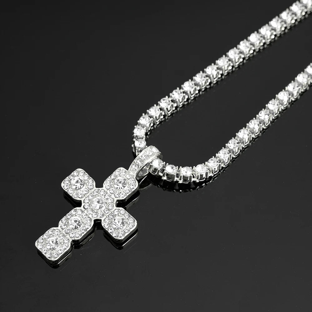 A sparkling rhinestone cross pendant necklace displayed against a dark background.
