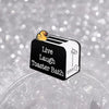 An enamel pin featuring a cartoon duck on a bread maker design.