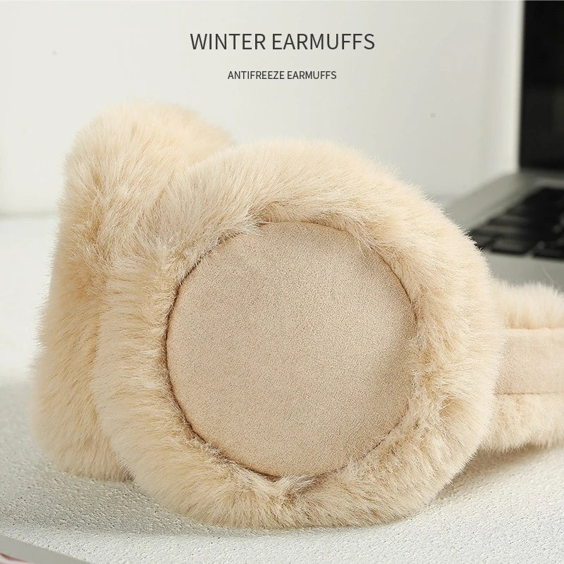 A beige faux fur winter earmuff with a circular padded ear covering is shown on a white surface.