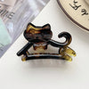 A set of cute cartoon animal hair clips shaped like cats, made of amber-colored resin.