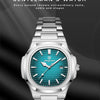 A silver men's watch with a blue dial and green bezel displayed against a dark background.