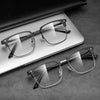 A pair of clear anti-blue light eyeglasses resting on a light-colored notebook or pad.