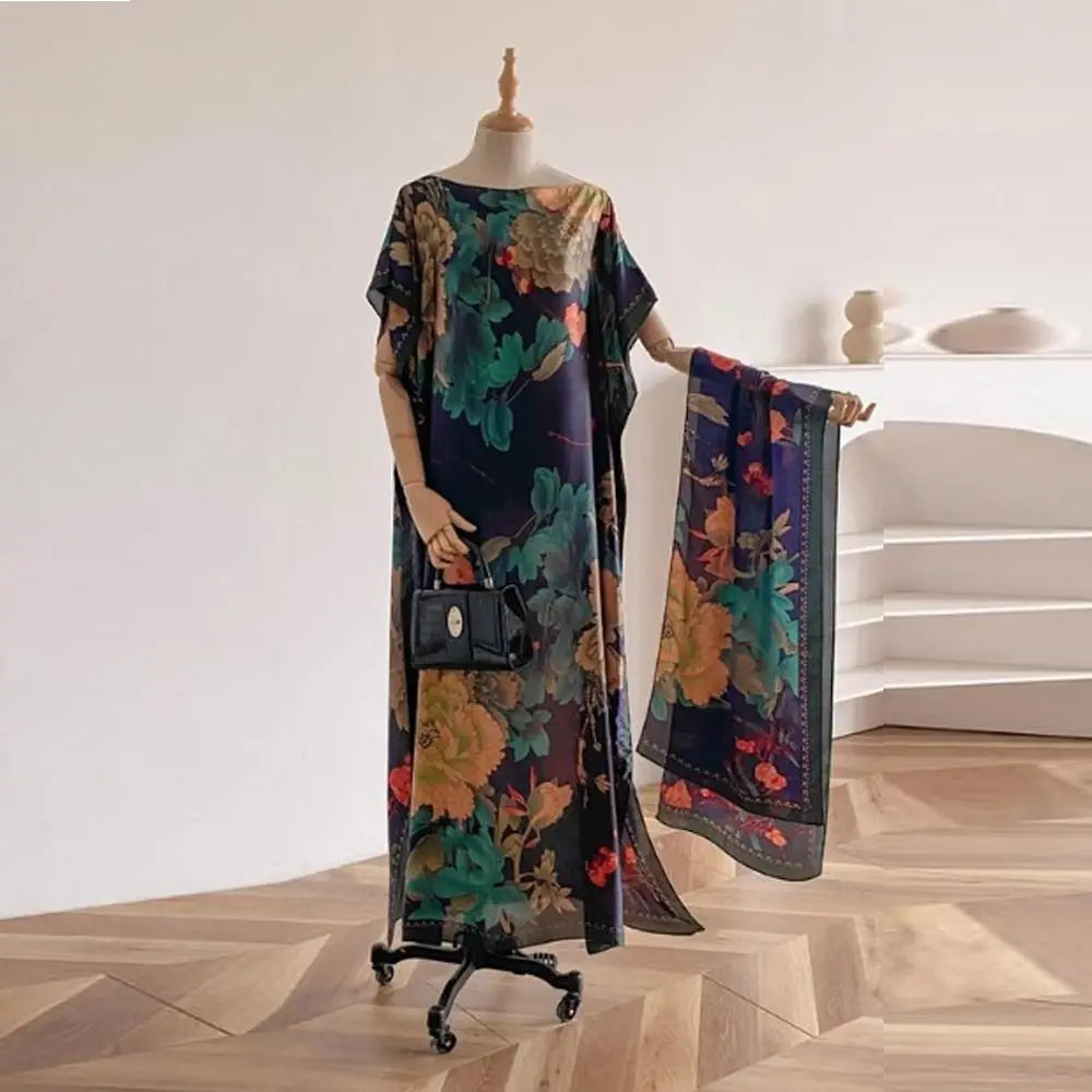 Châle cape à imprimé papillon floral sombre, exposé sur mannequin à côté d'une pochette noire.