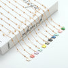 Gold-toned butterfly pendant necklace with delicate chain and small clear beads displayed on a white background.