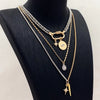 A multilayered gold and silver chain necklace featuring star eye pendants displayed on a black mannequin.