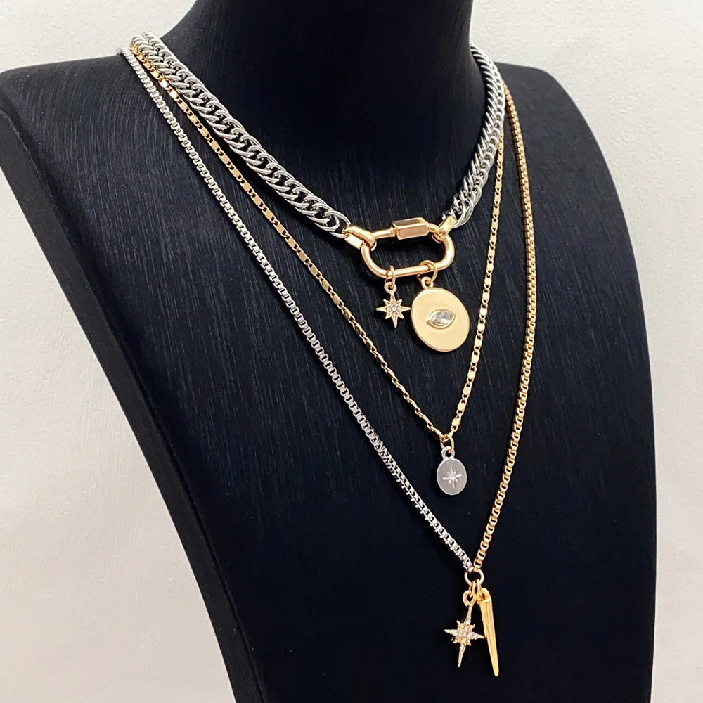 A multilayered gold and silver chain necklace featuring star eye pendants displayed on a black mannequin.