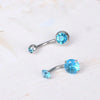 A pair of 14G stainless steel belly button piercing jewelry featuring bright blue cubic zirconia stones.