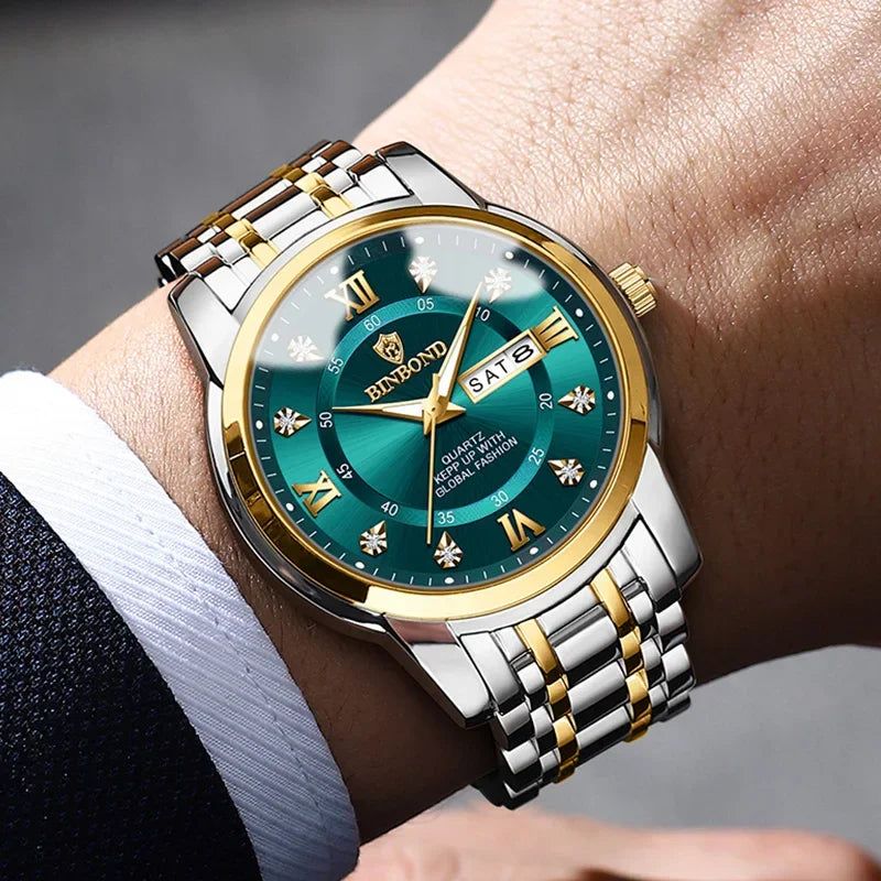 Primer plano de un reloj plateado y dorado con esfera verde oscuro y correa de cuero puesto en una muñeca.