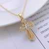 Gold vintage cross pendant necklace with clear stones on a white background.