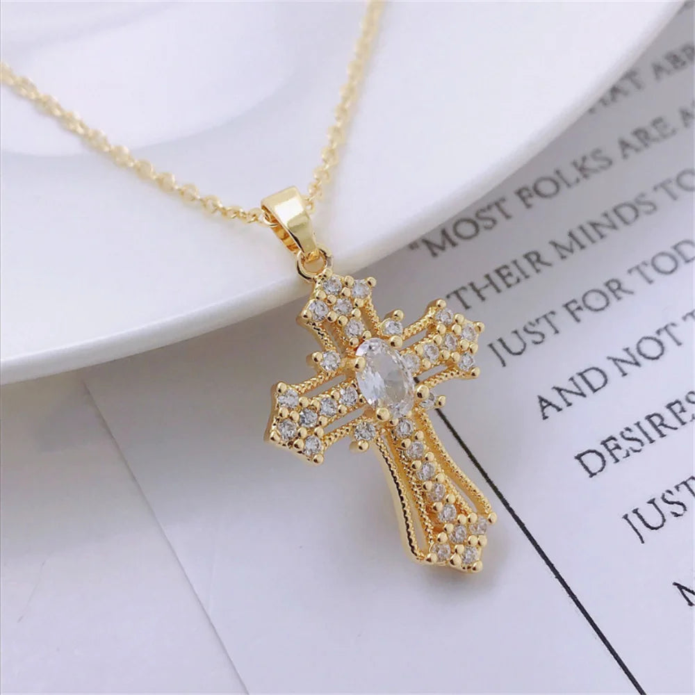 Gold vintage cross pendant necklace with clear stones on a white background.