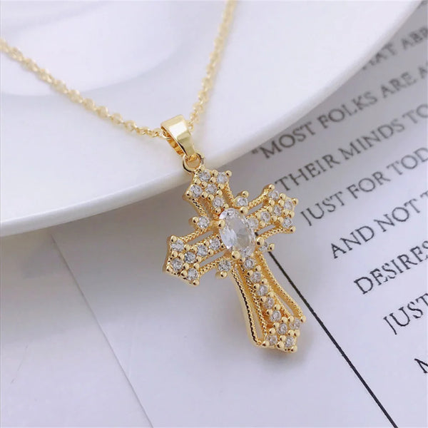 Gold vintage cross pendant necklace with clear stones on a white background.