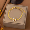 Goldfarbenes Edelstahl-Schmetterlings-Anhänger- und Armbandset in einer hellbraunen Box.