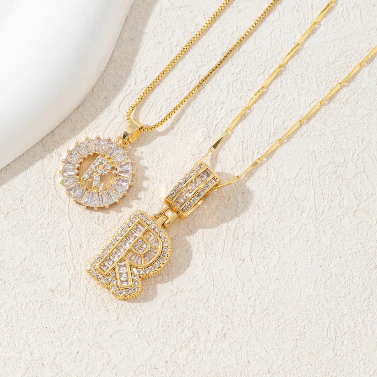 A gold necklace set featuring CZ crystal pendants shaped like the letters A and Z.