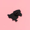 Schwarze Silhouette einer Krähe auf rosa Hintergrund, mit einer Emaille-Anstecknadel.