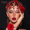A close-up portrait of a model wearing a red floral rhinestone bridal hair hoop and holding a red rose.