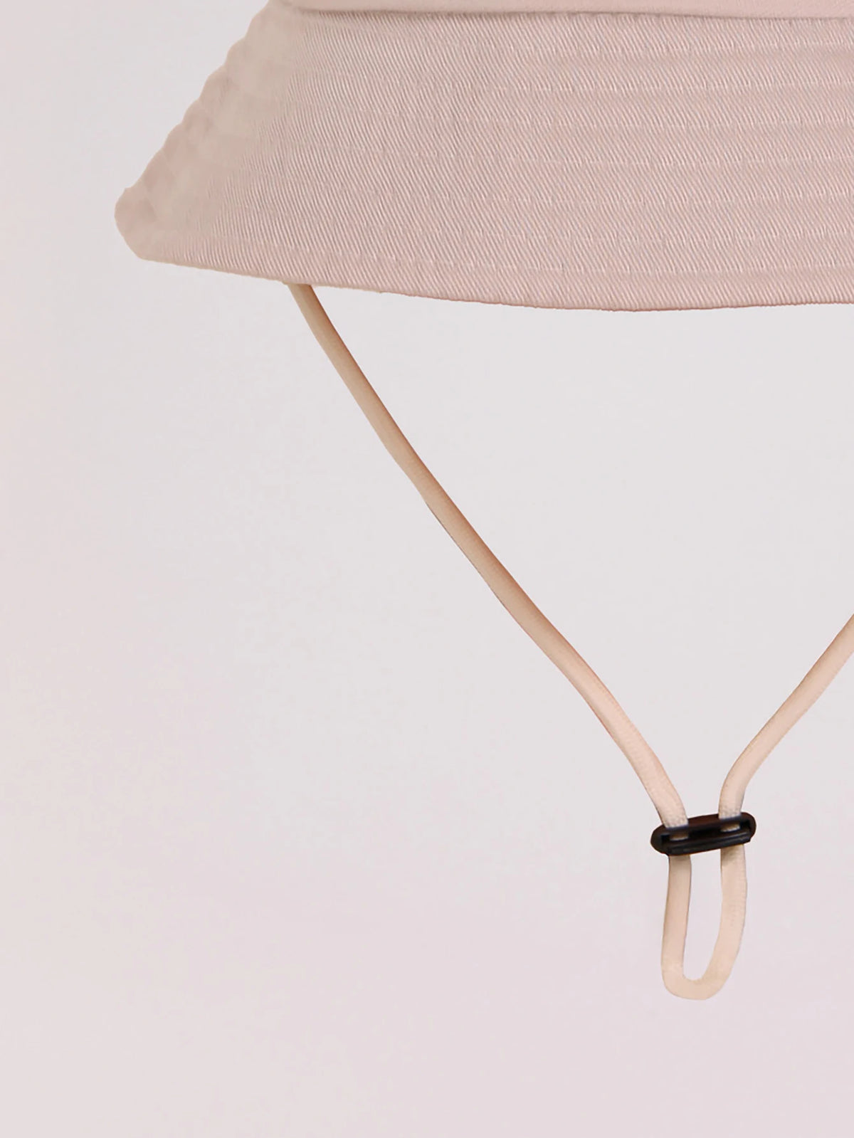 A beige letter print sun hat for kids with a light pink fabric and a thin strap.