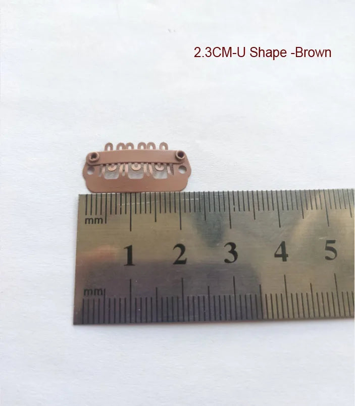 Pince d'extension de cheveux en forme de U marron de 2,3 cm à côté d'une règle.