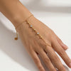 A close-up of a hand wearing an 18K gold plated stainless steel bracelet featuring small zircon stones and gold chain links.