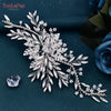 A delicate white rhinestone bridal headband or tiara with leafy and floral embellishments.
